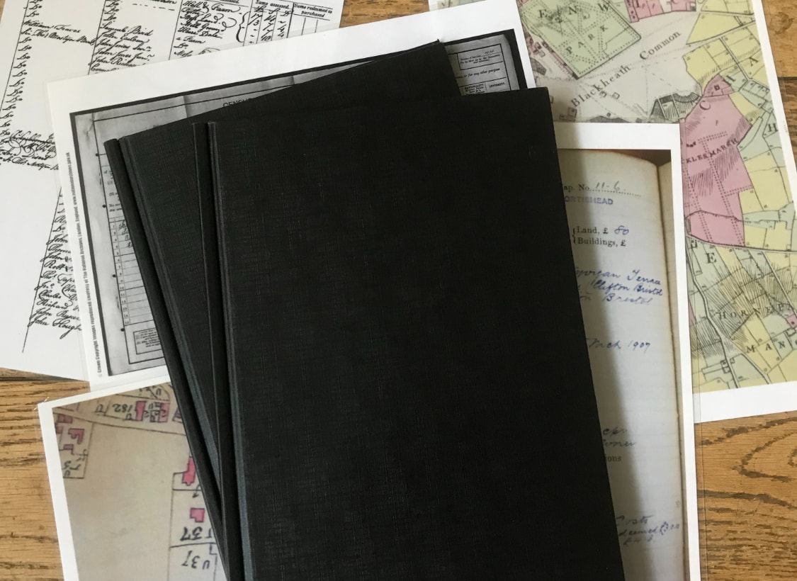 black front cover book with maps around the book on wooden table